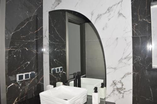 阿加迪尔Appartement 5 etoiles agadir vue mer的黑白浴室设有水槽和镜子