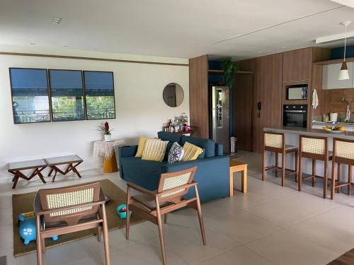 因巴塞Pé na areia - Reserva Ecológica - Tranquilidade的一间带蓝色沙发的客厅和一间厨房