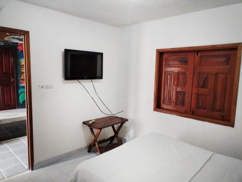 莱蒂西亚Divino Niño Hotel的一间卧室配有一张床,墙上配有电视