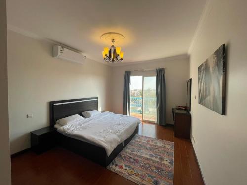 杜拉特阿拉尔Fun Beach - Durrat AL Arous的一间卧室配有一张床和一个吊灯