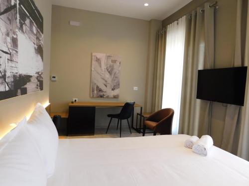 戈里察MIK Hotel Korce的酒店客房配有一张床和一张书桌及一台电视