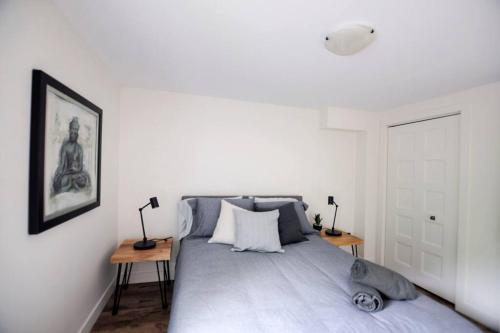 魁北克市Confo28 Chute Montmorency Parking的白色卧室配有一张带两张桌子的床