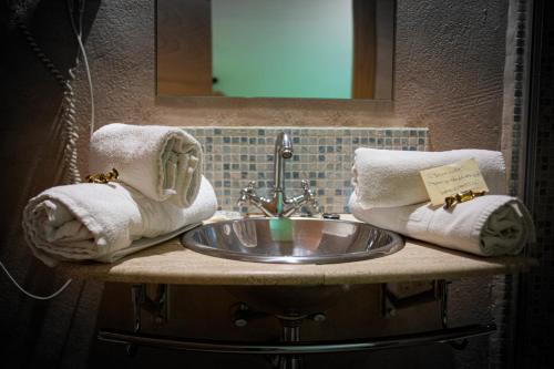 梅迪纳塞利Hostal Bavieca的浴室水槽配有毛巾和镜子