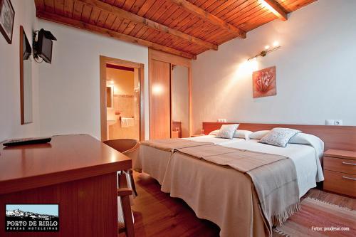 利洛Porto de Rinlo的一间卧室配有两张床、一张桌子和一个水槽