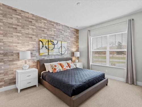 奥兰多LOCATION!! Modern Luxury Home 2 miles from Disney!的一间卧室设有砖墙和一张带枕头的床