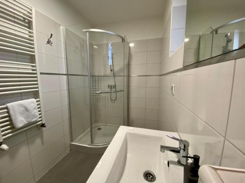 艾格扎洛克M&F Apartman的带淋浴和盥洗盆的白色浴室