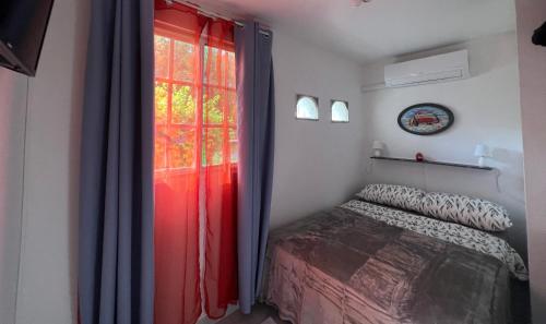 普拉亚科罗纳多Playa Coronado - piscine - Golf.的一间卧室配有床和红色窗帘的窗户