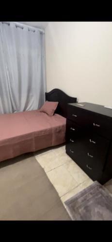 阿布扎比aldanah的一间卧室配有两张床、一个梳妆台和一张书桌。