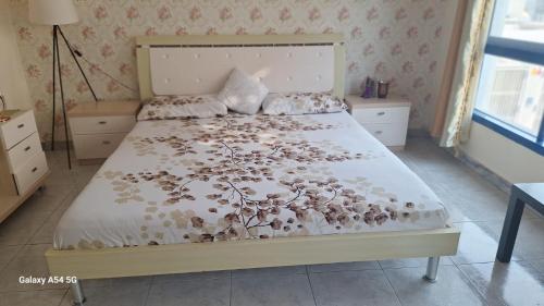 阿布扎比aldanah的一间卧室配有一张带花卉床罩的床