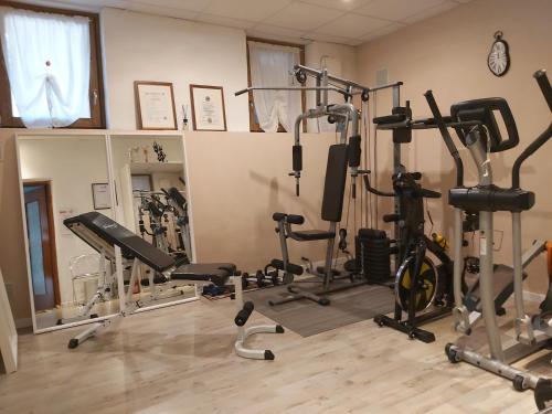 Pinasca B&B VALCHISONE的健身房设有数台跑步机和健身自行车
