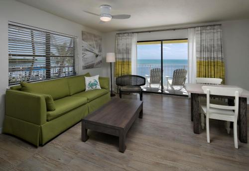 伊斯拉莫拉达La Siesta Resort & Villas的客厅配有绿色沙发和桌子