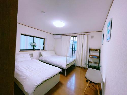 八王子市美山小屋-临近东京夏日乐园，高尾山，相模湖游乐园的一间小卧室,配有两张床和窗户