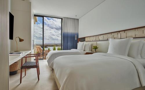 La RiberaFour Seasons Resort Los Cabos的酒店客房配有两张床和一张书桌
