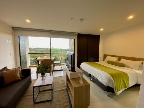 San AntonioRoom in BB - Luxurious mountain-view suite的一间卧室配有一张床、一张沙发和一台电视