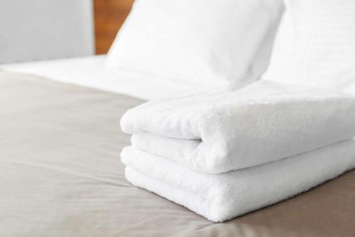 斯普林菲尔德密苏里州斯普林菲尔德德鲁套房旅馆的床上的白色毛巾堆
