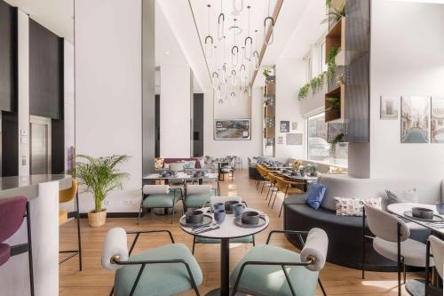 波尔图YOTEL Porto的一间带桌椅和天花板的餐厅