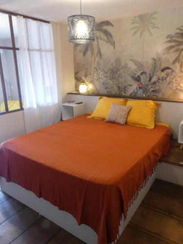 帕皮提Studio Poe Rava的一间卧室配有带橙色床单和黄色枕头的床。