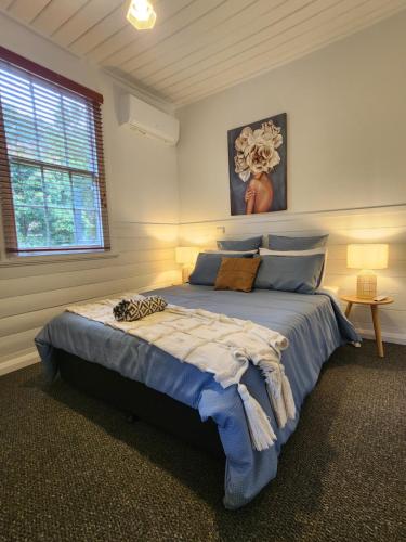 戴尔斯福特Daylesford - FROG HOLLOW ESTATE - The Homestead的一间卧室,卧室内配有一张蓝色大床