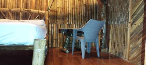 Santo DomingoHostal Inculta的一张蓝色椅子坐在一张桌子旁,放在一个房间里