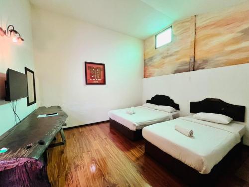 古晋古晋海滨旅舍的酒店客房配有两张床和一张书桌