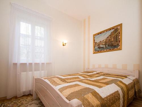 尤尔马拉力士公寓的卧室配有一张床,墙上挂有绘画作品
