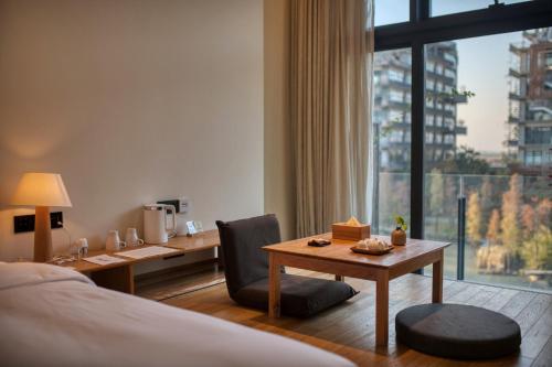 宝安深圳泰华梧桐酒店的酒店客房配有书桌、床和桌子。