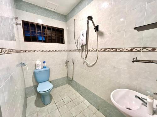 淡文Pleasant Stay @ Sunway (16-20 pax ) 5 min to Lost World of Tambun的浴室设有蓝色的卫生间和水槽。