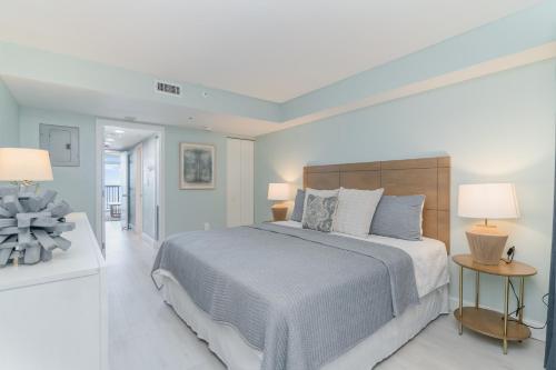 默特尔比奇Ocean Breeze的白色卧室配有一张大床和两盏灯。