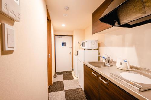 京都HOTEL THE POINT Kiyomizu Gojo的一间带水槽和冰箱的小厨房