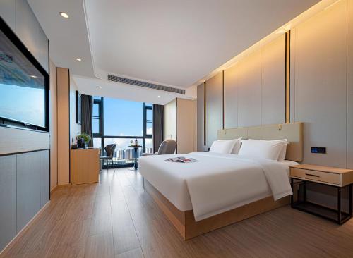 张家界Zhangjiajie Hero Boutique Hotel的卧室配有一张白色大床和电视。