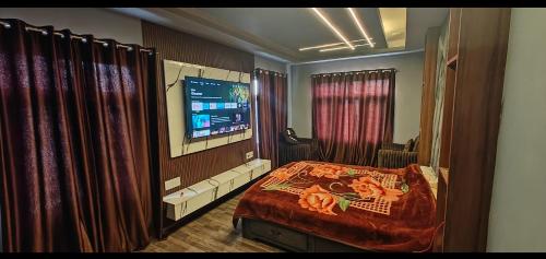 斯利那加Home sleeper的一间卧室配有床、电视和窗帘
