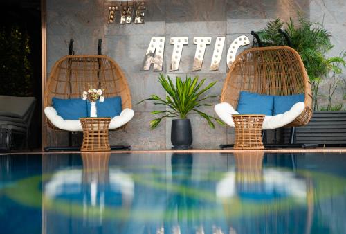 胡志明市Northern Charm Hotel的游泳池畔的两把带蓝色枕头的椅子