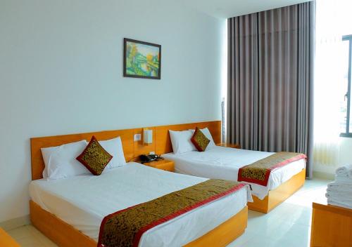 芽庄Khách sạn Phố Ngọc的酒店客房设有两张床和窗户。
