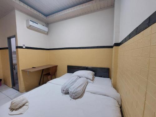查亚普拉OYO 93332 Kharis Home Stay的一间卧室配有带白色床单和枕头的床。
