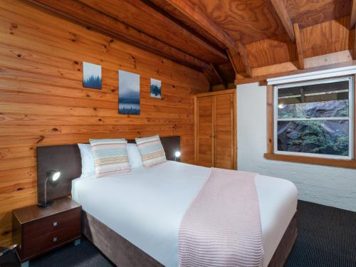 朗塞斯顿皮尼皇家休闲酒店和公寓的木制客房内的一间白色床卧室