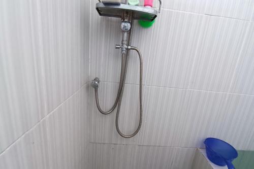 SukoharjoSPOT ON 93317 Wisma Ratu Syariah的墙上的软管淋浴