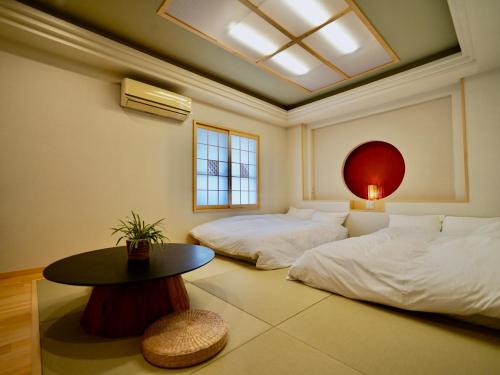 石垣岛Hotel Ishigaki and Chikonkiya的一间设有两张床和一张桌子的房间