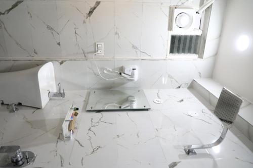 海得拉巴The Nectar Hotel的白色瓷砖浴室设有水槽和卫生间