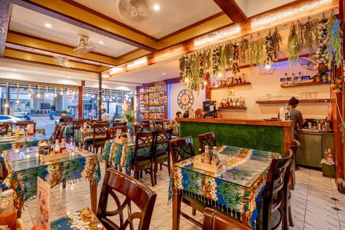 芭东海滩Patong Social Hotel & Restaurant的一间带桌椅的餐厅和一间酒吧
