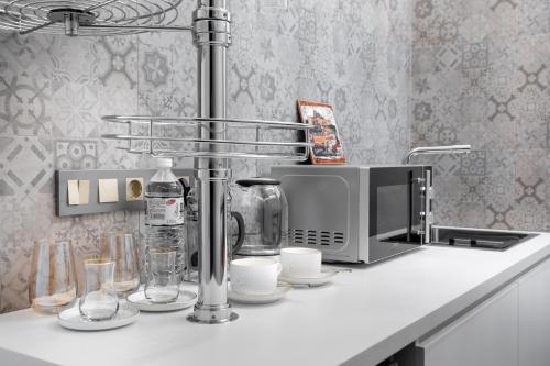 阿拉木图Apart Hotel Colibri的厨房柜台配有咖啡机和微波炉