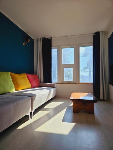 济州市MO Guesthouse的一间卧室配有一张带色彩缤纷枕头的床和一张桌子