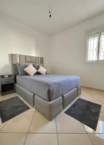得土安Quartier Administratif的一间卧室配有一张带两张地毯的床