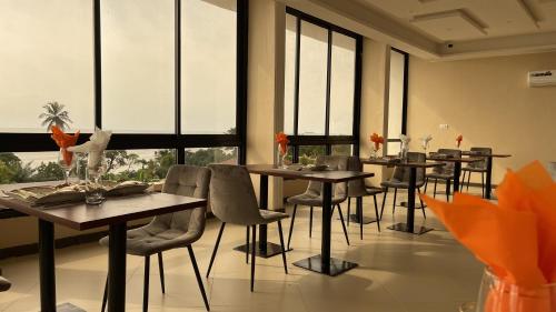 克里比SKY KENAKO HOTEL的用餐室设有桌椅和窗户。