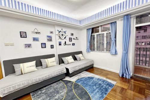 香港Fantastic Queen beds, 4Rms beside MTR grand 14ppls 2 bathrm的带沙发和窗户的客厅
