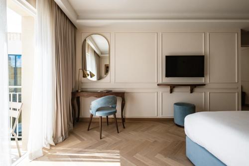 Hal GhaxiakPalazzo Castagna Boutique Hotel的一间卧室配有一张床、一张书桌和一台电视。