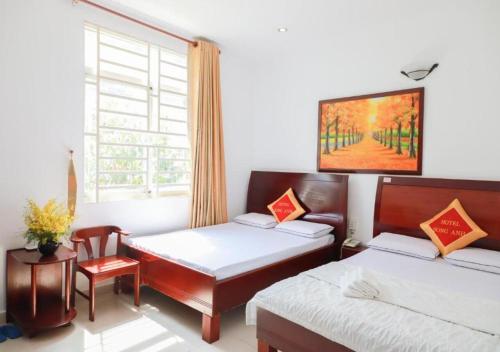 胡志明市Khách sạn Song Anh的一间卧室设有两张床和窗户。
