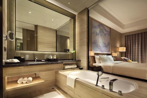 黄石黄石富力万达嘉华酒店的一间带床、水槽和浴缸的浴室
