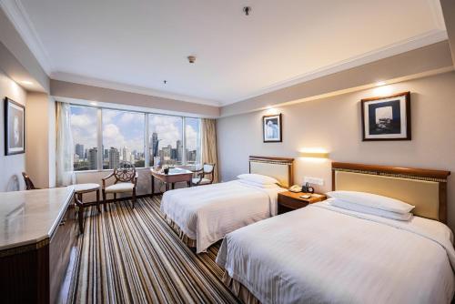 上海上海新锦江大酒店的酒店客房设有两张床和窗户。