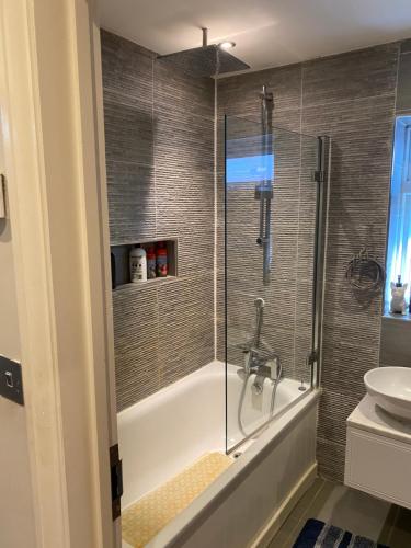莱斯里普Ruislip Guest House的带淋浴、浴缸和盥洗盆的浴室
