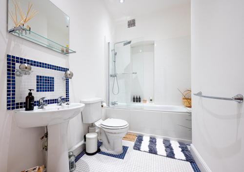 伦敦Cosy 1-Bed Apartment in Central London Old Street的浴室配有卫生间、盥洗盆和浴缸。